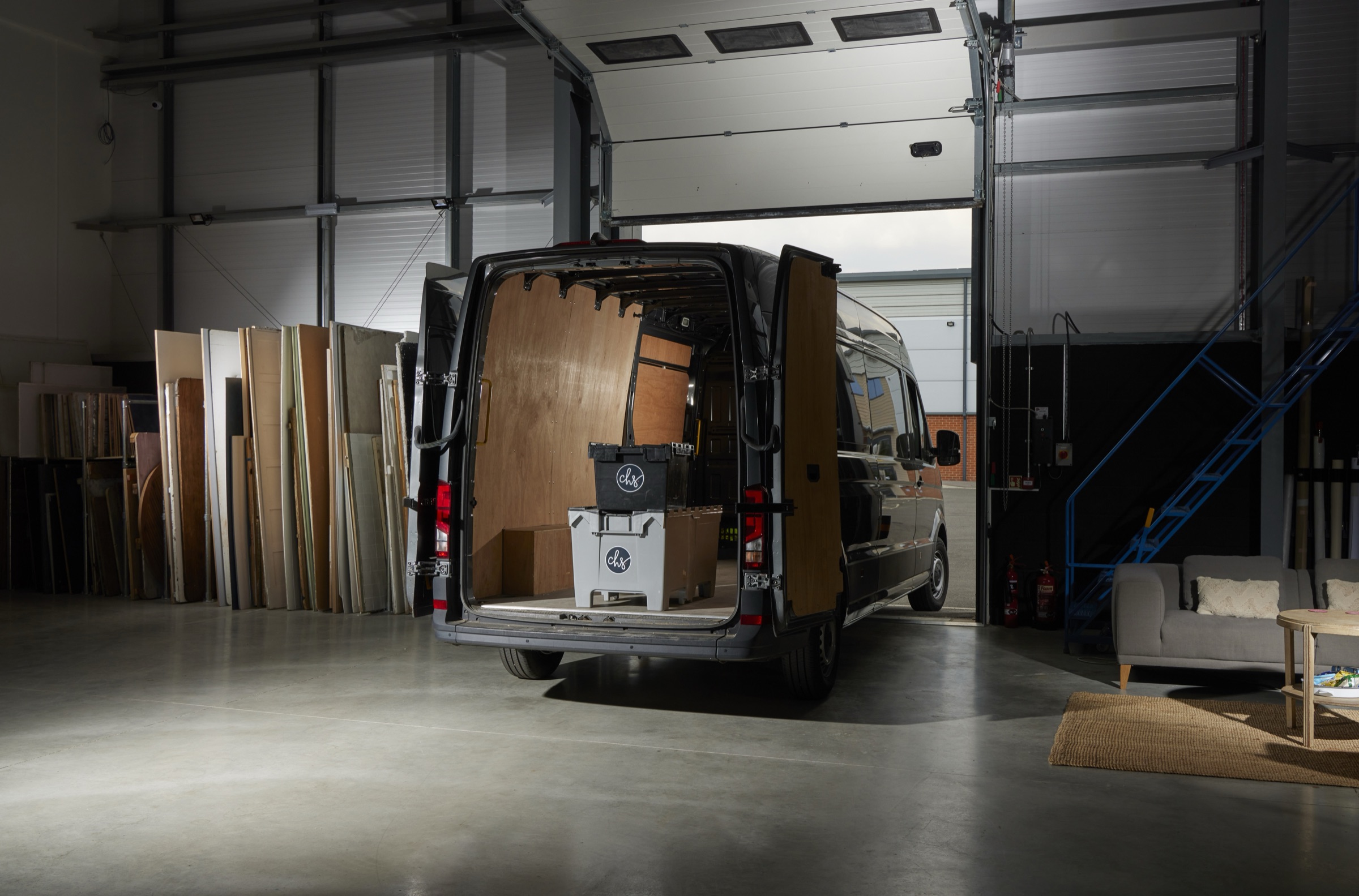 A long-wheelbase van parked fully inside the studio through the electric loading door