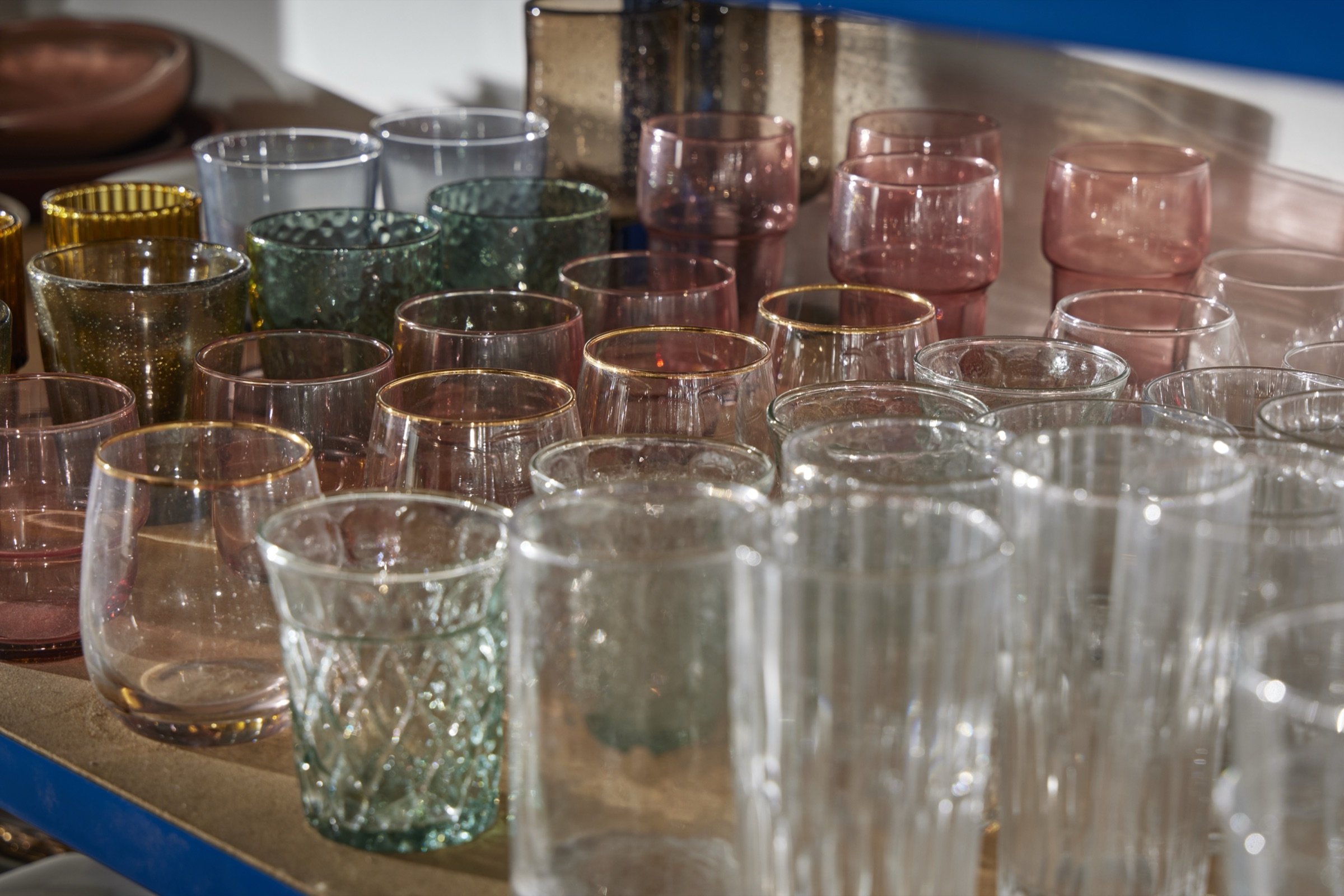 Coloured and gold-rimmed glassware on the props store shelves