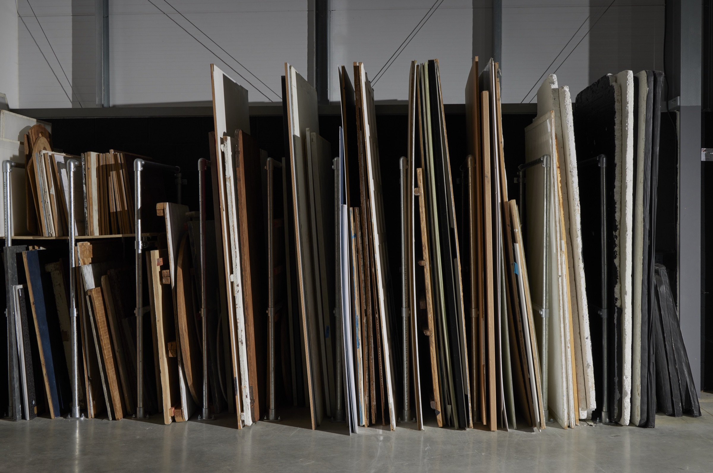 The surfaces rack: hand-built painted boards and tabletops in tube-clamp slots